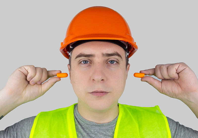Travailleur qui met des bouchons d'oreille